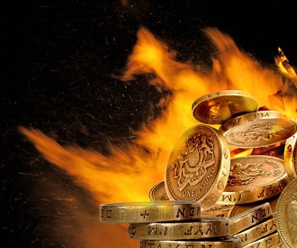 B50H11 One pound coins burning in a fire.